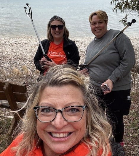 3 volunteers holding trash grabbers
